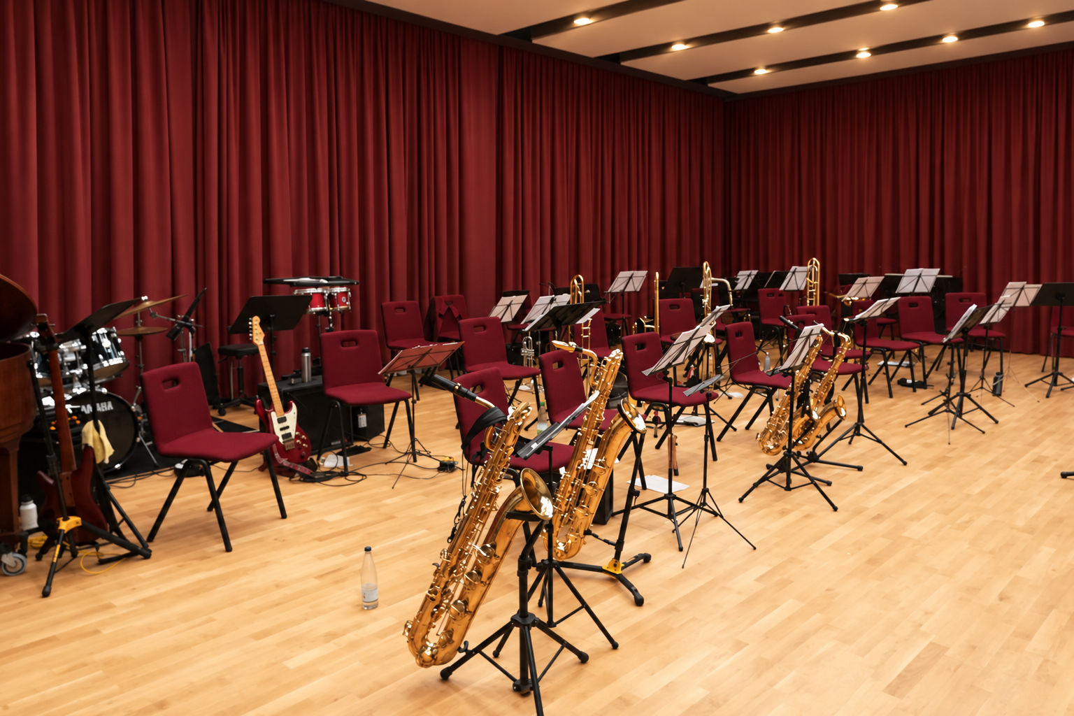 Big-Band-Aufbau mit Instrumenten, Notenständern und rotem Vorhang